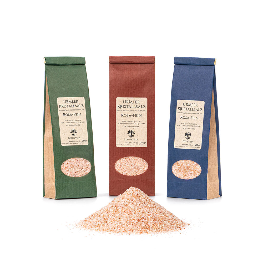 Drei 250g-Beutel mit fein gemahlenem, rosa Kristallsalz in grüner, roter und blauer Verpackung, davor eine kleine Menge des losen Salzes.