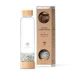 Edle Glas-Trinkflasche mit Bambus-Akzenten und einer separaten Kammer gefüllt mit einer Mischung aus Amazonit- und Rosenquarz-Edelsteinen, stehend neben ihrer Kartonverpackung.