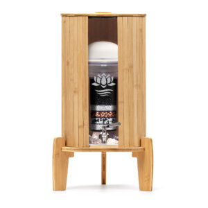 Ein Glas-Wasserfilter von Lotus Vita, auf einem Bambus-Standfuß stehend und ausgestattet mit einem Bambus-Deckel sowie einem passenden Lichtschutz aus Bambus.