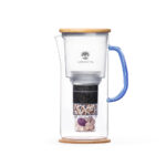 Eine Glaskaraffe mit einem mehrstufigen Wasserfilter, der Aktivkohle, Mineralien und Edelsteine enthält, ausgestattet mit einem Holzdeckel und einem blauen Griff.